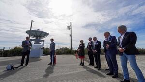 A group standing by a radar dish