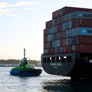 tug boat next to a large container ship
