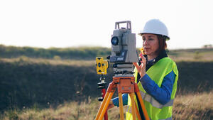 Female surveyor using a tripod outside