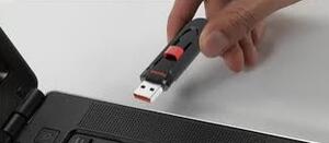 A USB drive being put into a USB port on a computer