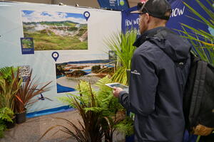 Person standing at the LINZ Fieldays stand with an ipad